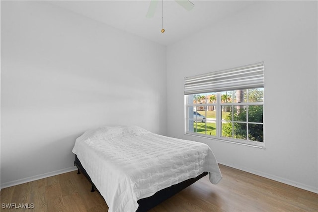 bedroom featuring a ceiling fan, baseboards, and wood finished floors