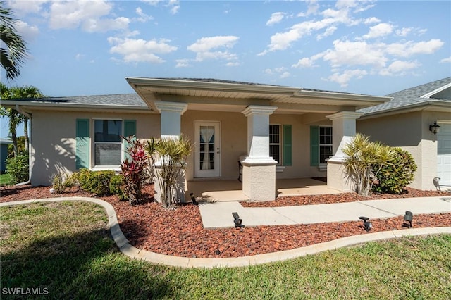 417 NW 3rd Ter, Cape Coral, FL 33993 - view of front of house with stucco siding, a porch, and an attached garage