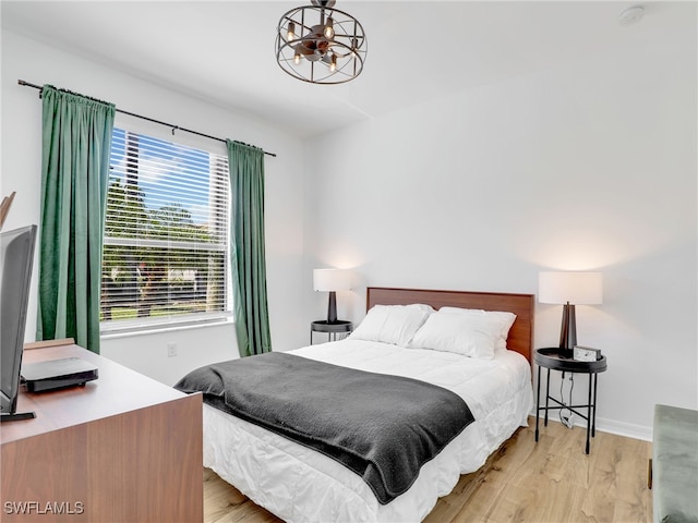 bedroom with light wood-style flooring and baseboards