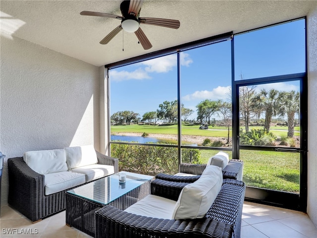 sunroom featuring a water view and a ceiling fan