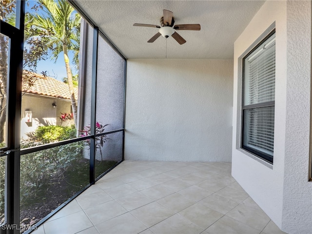 unfurnished sunroom featuring a ceiling fan