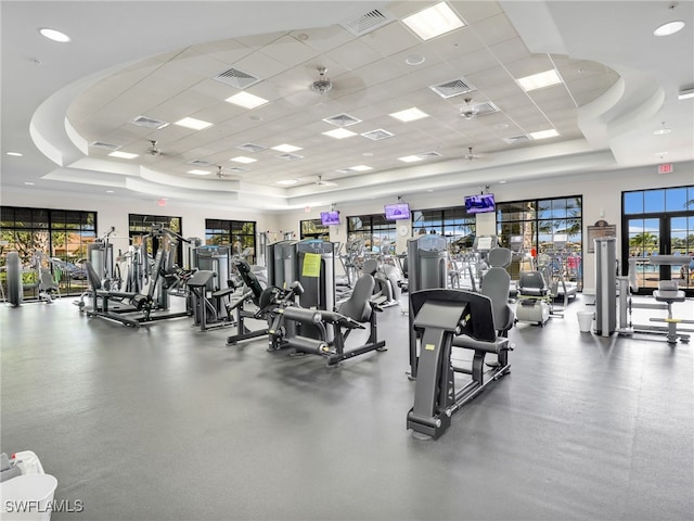 gym featuring visible vents and a raised ceiling