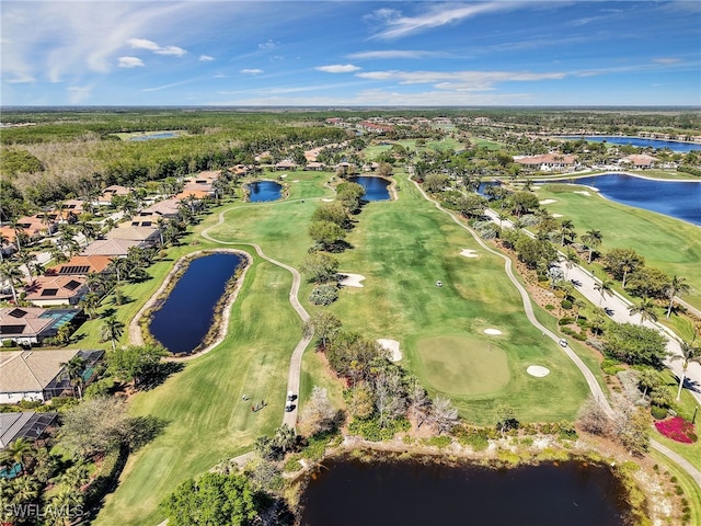 drone / aerial view with a water view and view of golf course