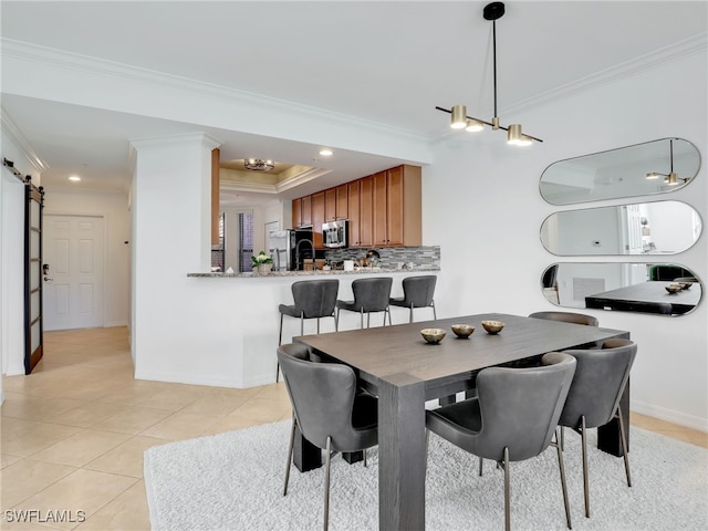 dining area featuring light tile patterned floors, baseboards, ornamental molding, a barn door, and a raised ceiling