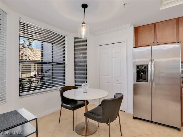 dining space featuring baseboards, light tile patterned flooring, and crown molding