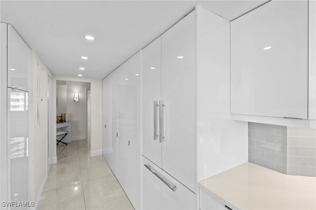 hall featuring light tile patterned floors, recessed lighting, and baseboards