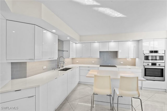 kitchen featuring a sink, white cabinetry, double oven, black electric cooktop, and modern cabinets