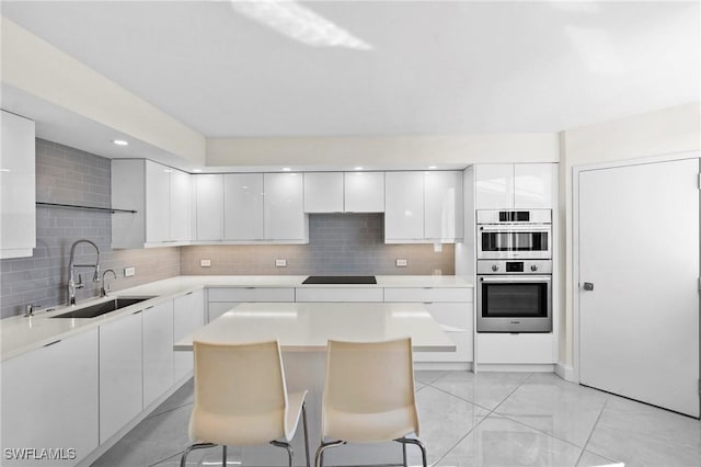 kitchen featuring a sink, black electric stovetop, and modern cabinets