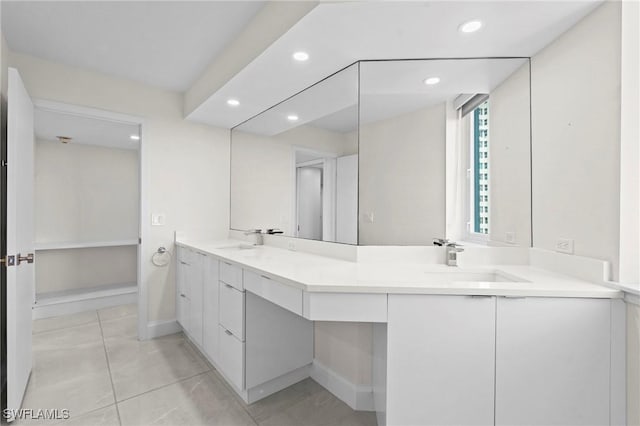 full bath featuring double vanity, recessed lighting, baseboards, and a sink