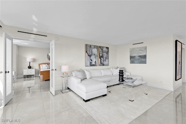 living area with baseboards and marble finish floor