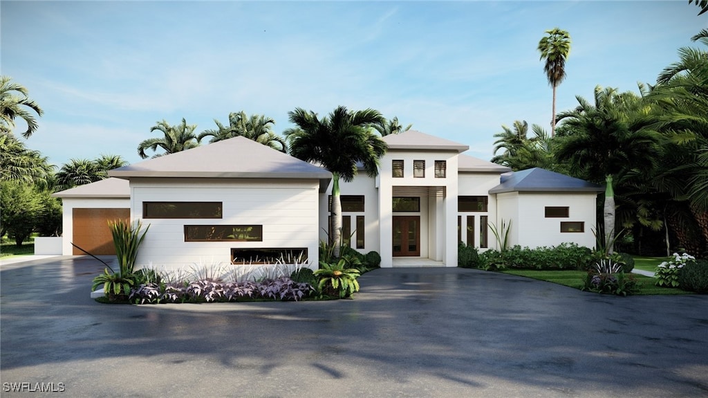 view of front facade featuring stucco siding, french doors, and a garage