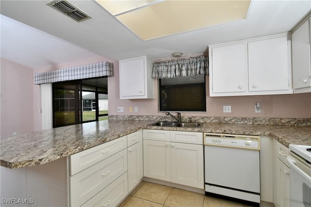 kitchen with visible vents, a sink, white cabinetry, white appliances, and a peninsula