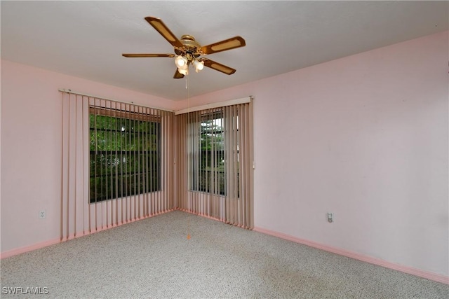 unfurnished room featuring a ceiling fan and baseboards