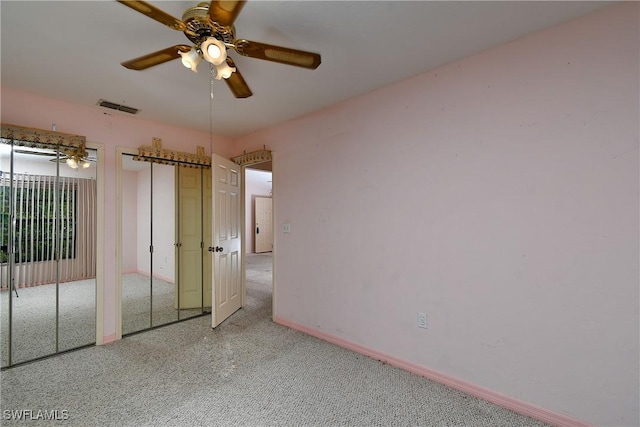 unfurnished bedroom featuring visible vents, baseboards, ceiling fan, and multiple closets