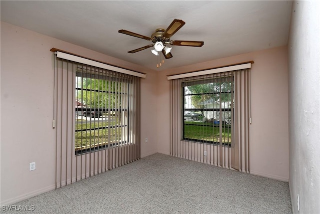 carpeted spare room with a ceiling fan