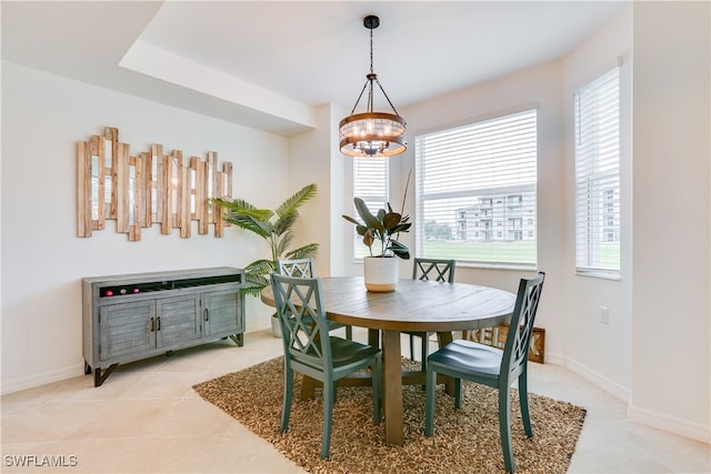 dining space with a chandelier, baseboards, and light tile patterned flooring