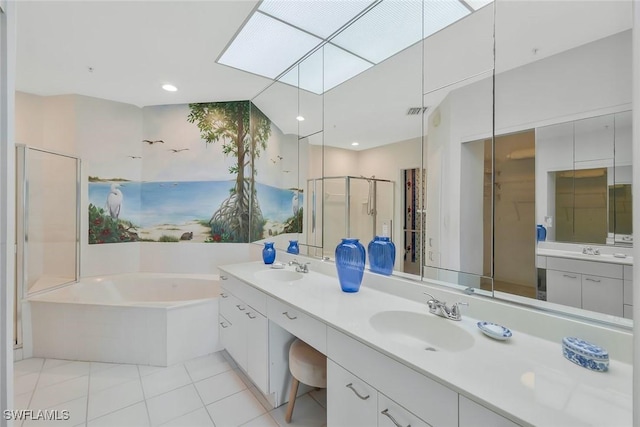 bathroom featuring a stall shower, tile patterned flooring, a sink, and a garden tub