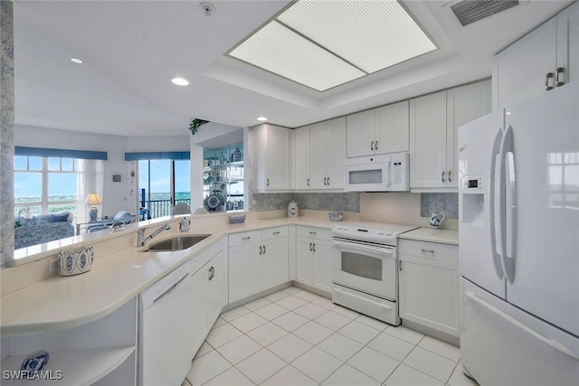 kitchen with light countertops, visible vents, white appliances, white cabinetry, and a sink
