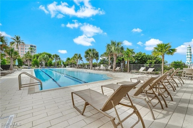 pool with a patio and fence