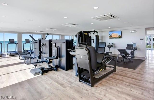 workout area with plenty of natural light, wood finished floors, and recessed lighting