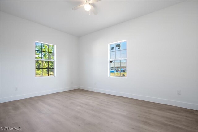 spare room with baseboards, a ceiling fan, and wood finished floors
