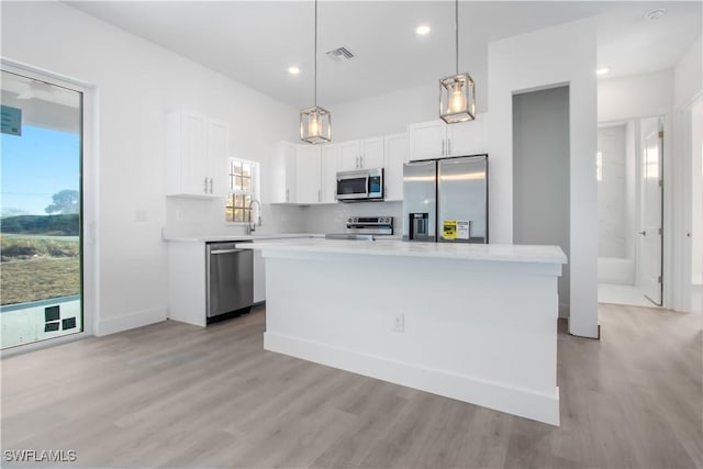 kitchen featuring light countertops, light wood-style floors, stainless steel appliances, and visible vents