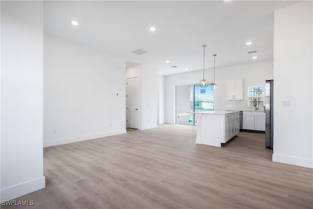 unfurnished living room with baseboards, light wood-style floors, and recessed lighting