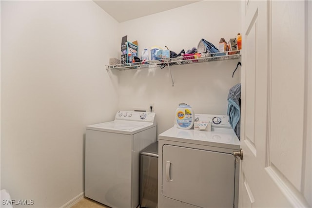 laundry room with laundry area, baseboards, and washing machine and clothes dryer