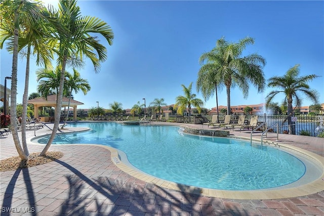 pool with a gazebo, a patio, and fence