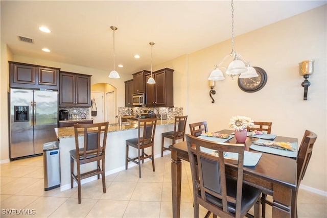 dining area featuring visible vents, recessed lighting, arched walkways, light tile patterned floors, and baseboards