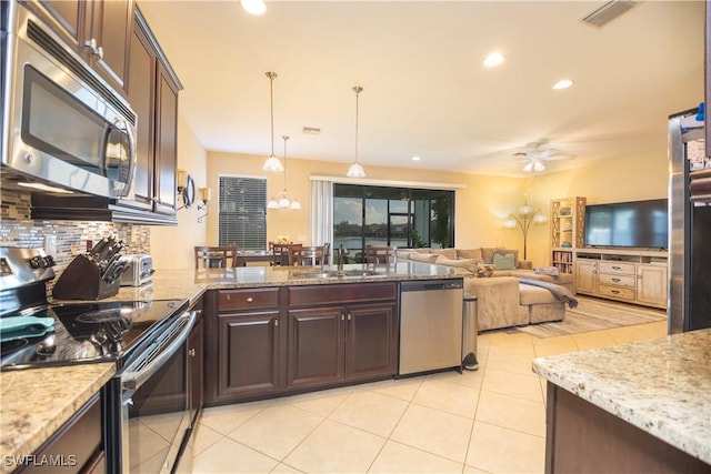 kitchen featuring visible vents, a sink, backsplash, dark brown cabinetry, and appliances with stainless steel finishes