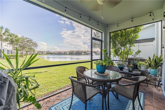 sunroom with a water view and a ceiling fan