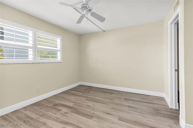 spare room featuring baseboards, light wood-style floors, and ceiling fan