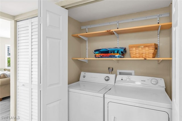 clothes washing area with independent washer and dryer and laundry area