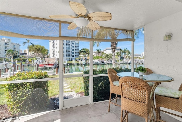 sunroom with a water view and a ceiling fan