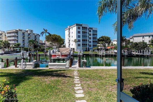 view of dock with boat lift, a water view, and a lawn