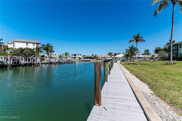 dock area with a yard, a water view, and a residential view