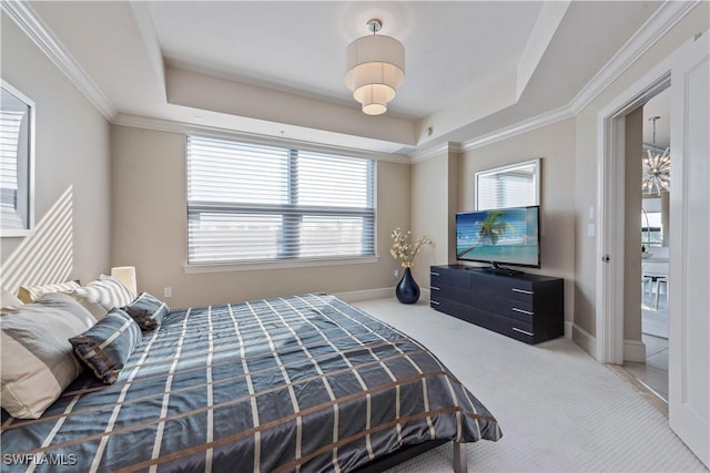 carpeted bedroom with a tray ceiling, baseboards, and ornamental molding