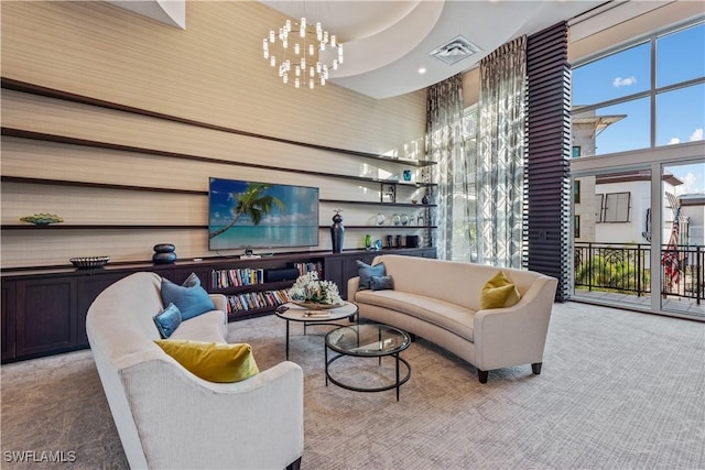 living area with a chandelier, visible vents, carpet flooring, and a towering ceiling