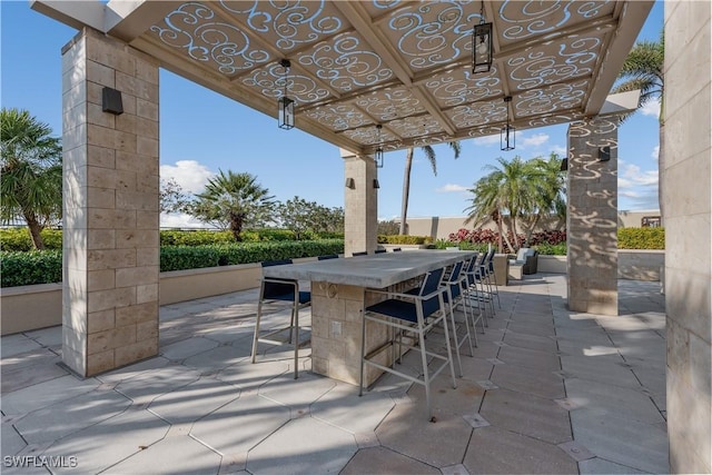 view of patio / terrace featuring outdoor dry bar and a pergola