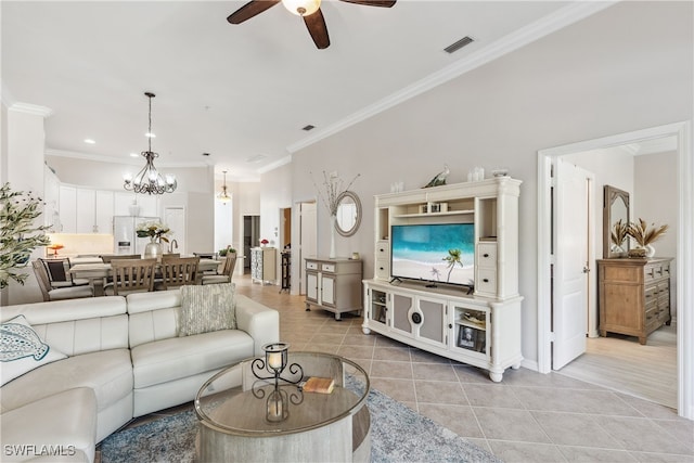 living room with crown molding, light tile patterned floors, ceiling fan with notable chandelier, and visible vents