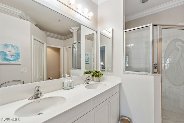 bathroom with crown molding, double vanity, a shower stall, and a sink