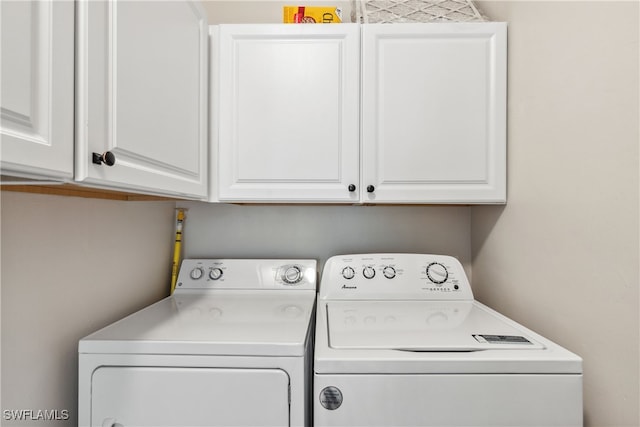 laundry area featuring washer and clothes dryer and cabinet space