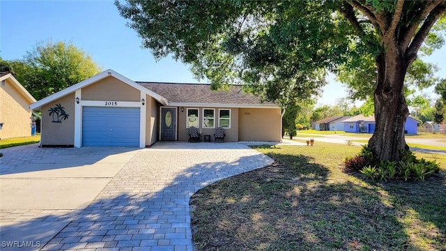 ranch-style house featuring a garage, driveway, and stucco siding