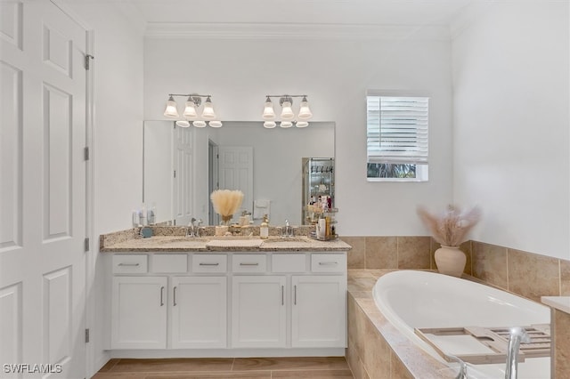 bathroom featuring double vanity, ornamental molding, a bath, and a sink