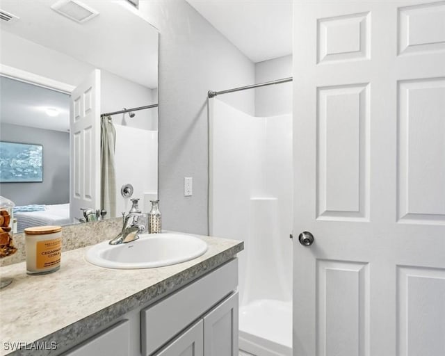 full bath with curtained shower, vanity, and visible vents