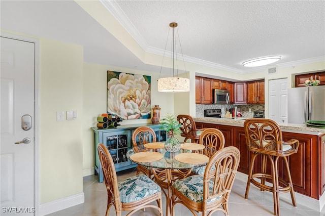 dining room featuring light tile patterned floors, visible vents, a textured ceiling, and crown molding