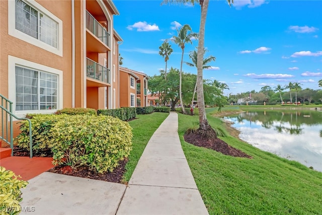 surrounding community with a yard and a water view