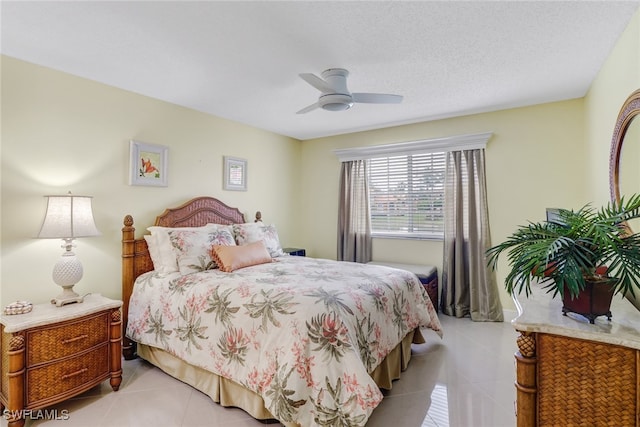 bedroom featuring a textured ceiling, tile patterned floors, and ceiling fan