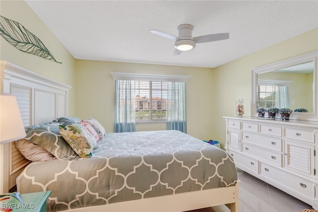 bedroom with ceiling fan, multiple windows, and a textured ceiling